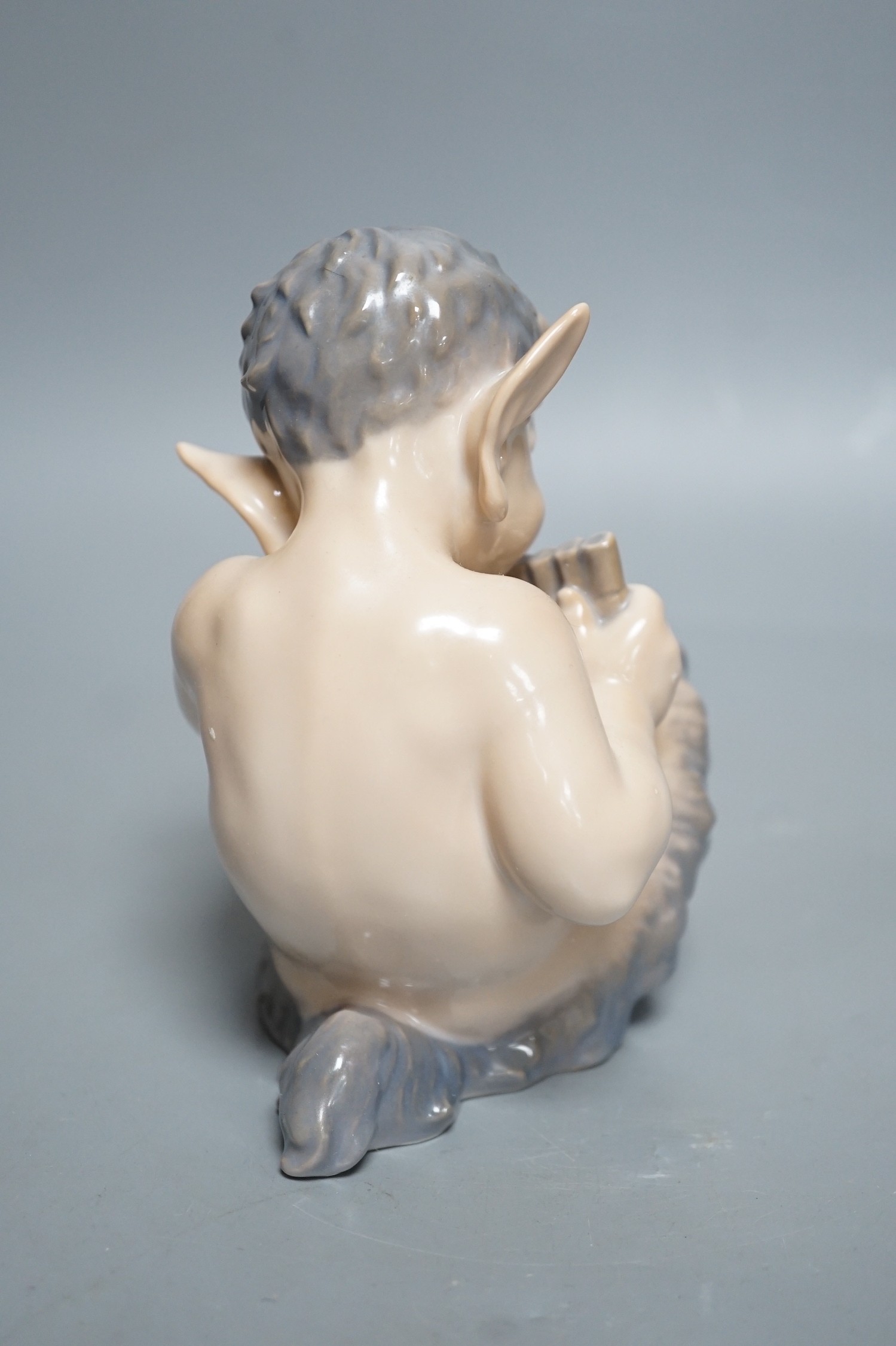 A Royal Copenhagen porcelain model of a seated faun, number 1736, 13cm tall